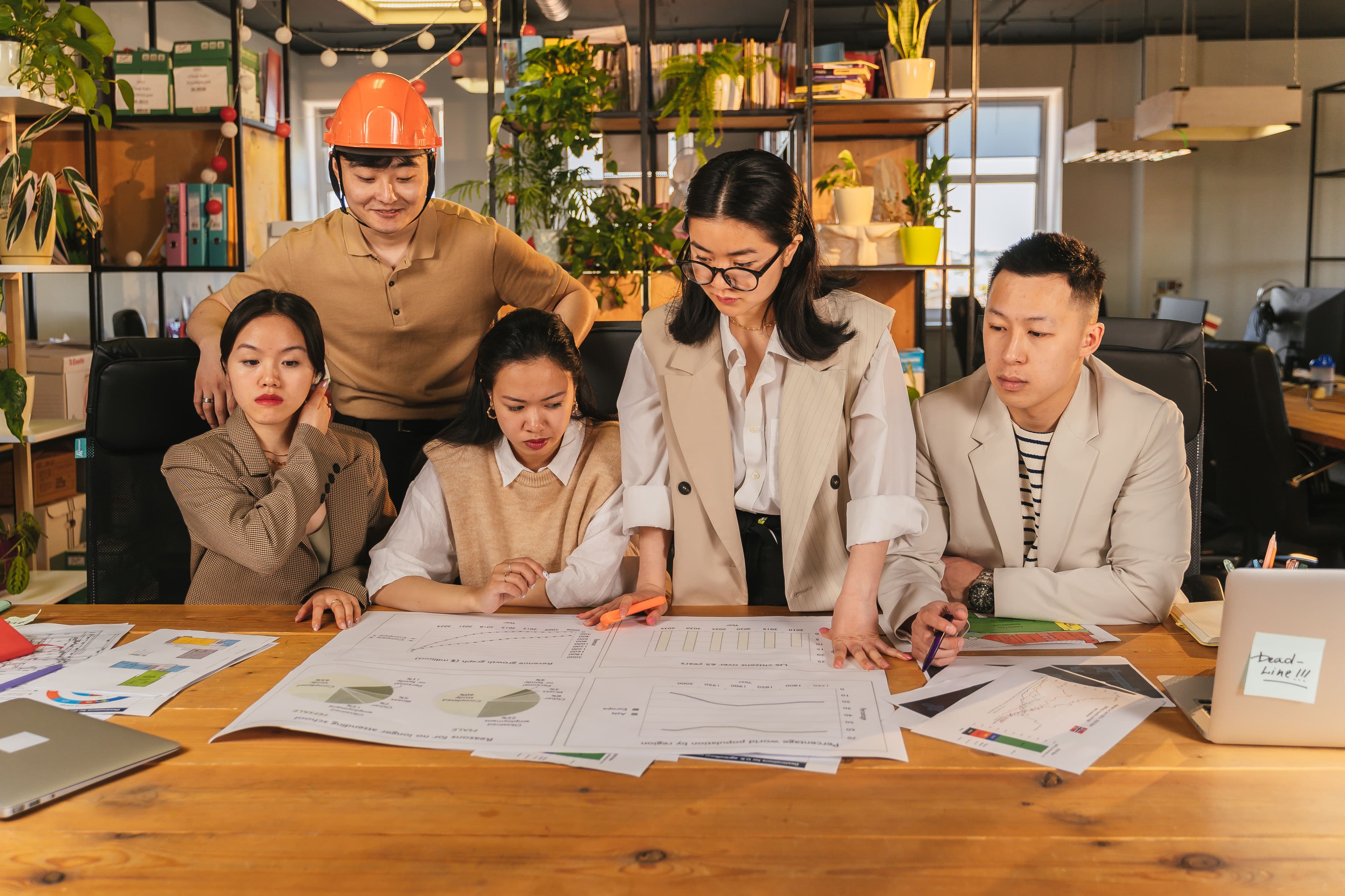 A team reviewing charts and reports spread across a desk