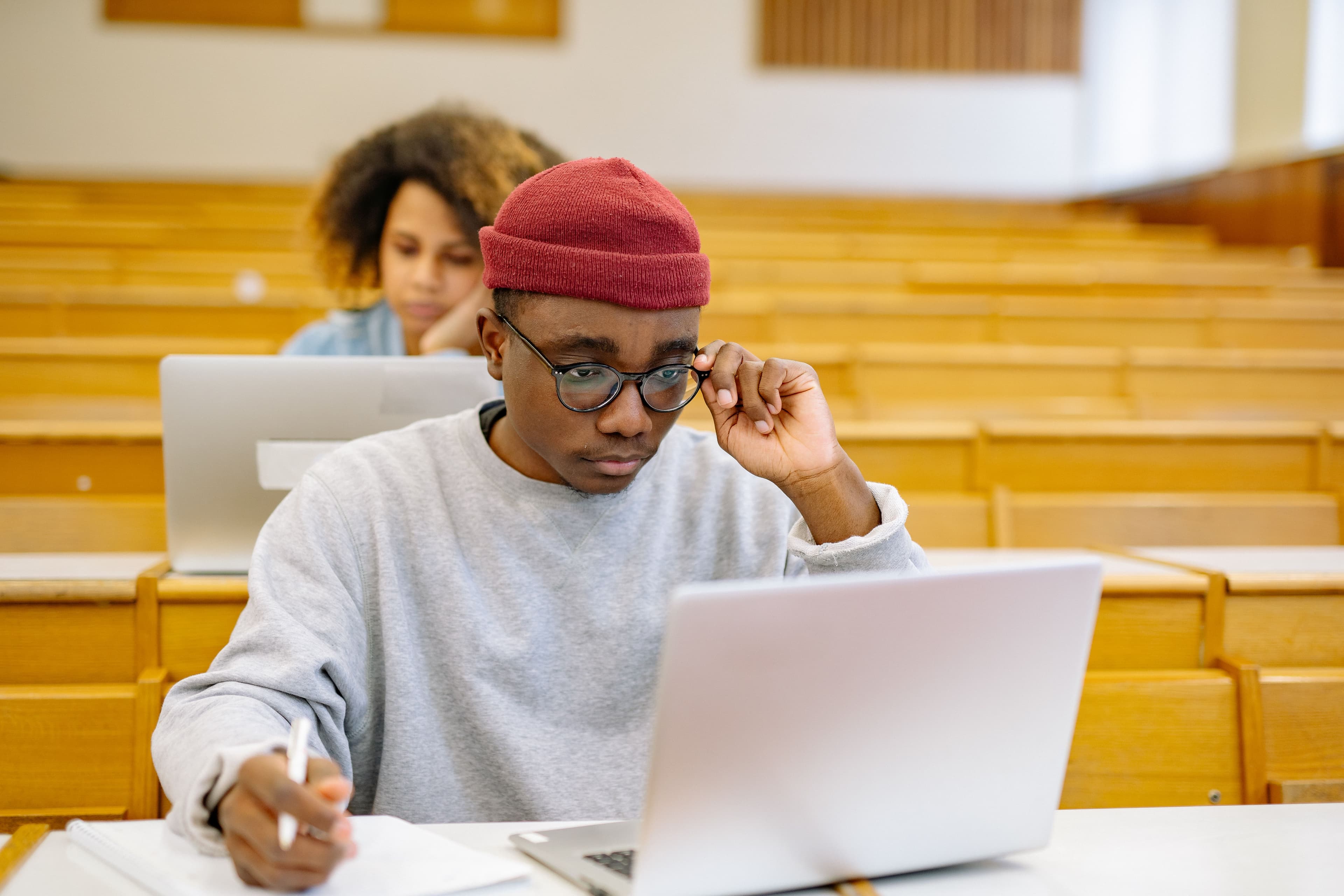 A student studying with a laptop in a lecture hall