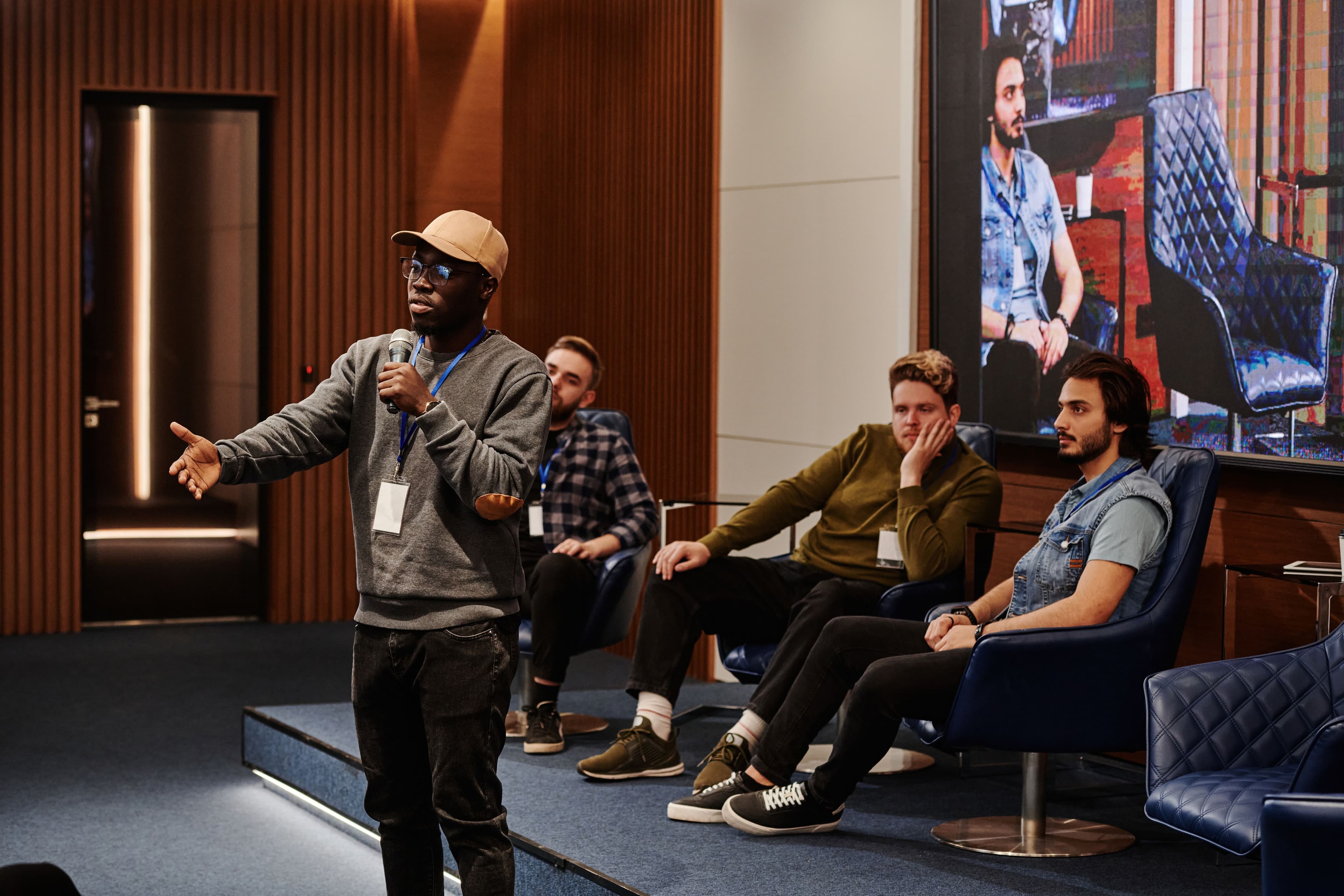 A panel speaker addressing an audience on stage at a conference