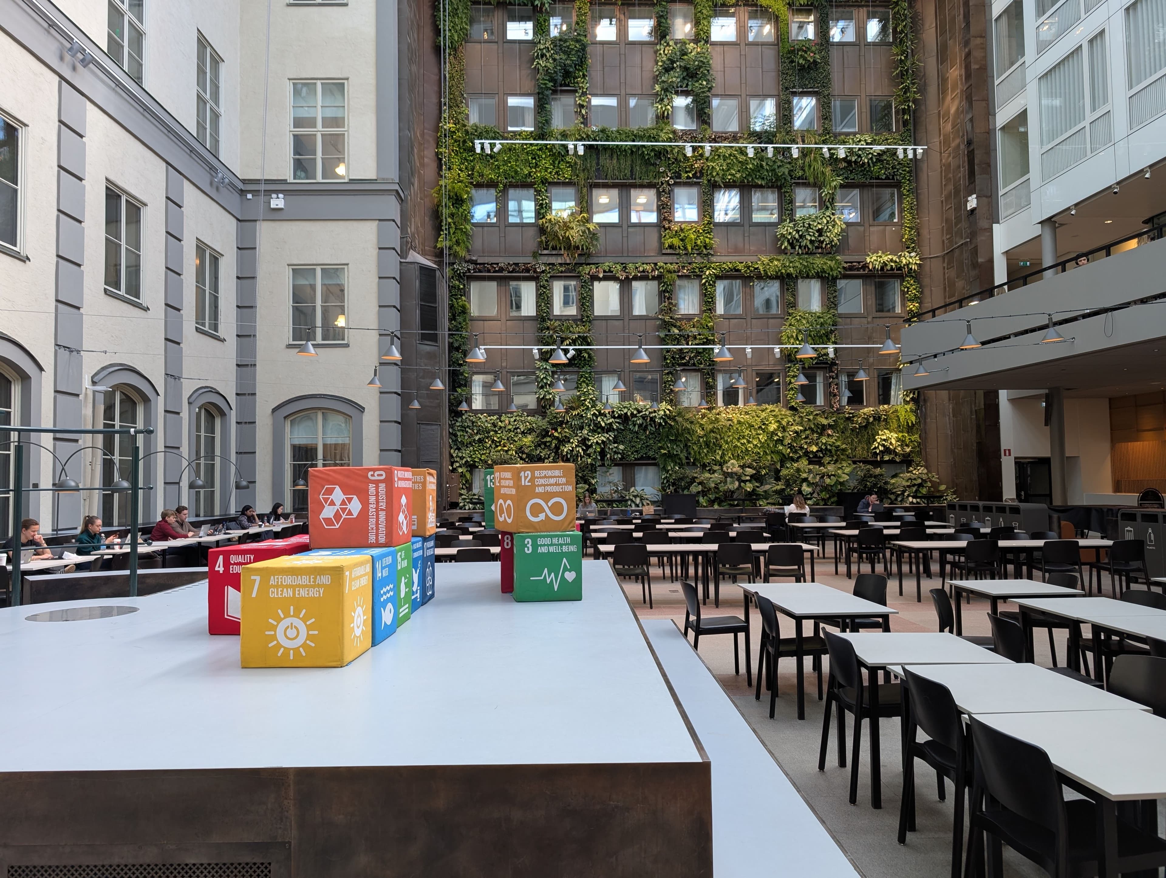 SDG-themed seating cubes in a university courtyard where students are working